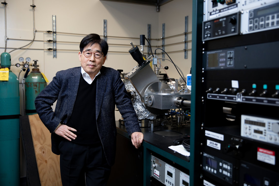 Prof. Hong in a laboratory in front of various scientific equipment